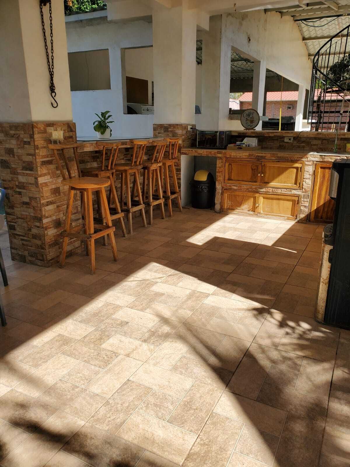Un espace extérieur abrité, doté d’un bar et de sièges.