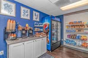 A coffee station with Keurig machines, a Pepsi refrigerator, and snack shelves.