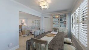 A dining area with a wooden table, chairs, and a buffet cabinet. - BG Beach Club 3C | 3BR/2BA Boca Grande | Pool View (Boca Grande)