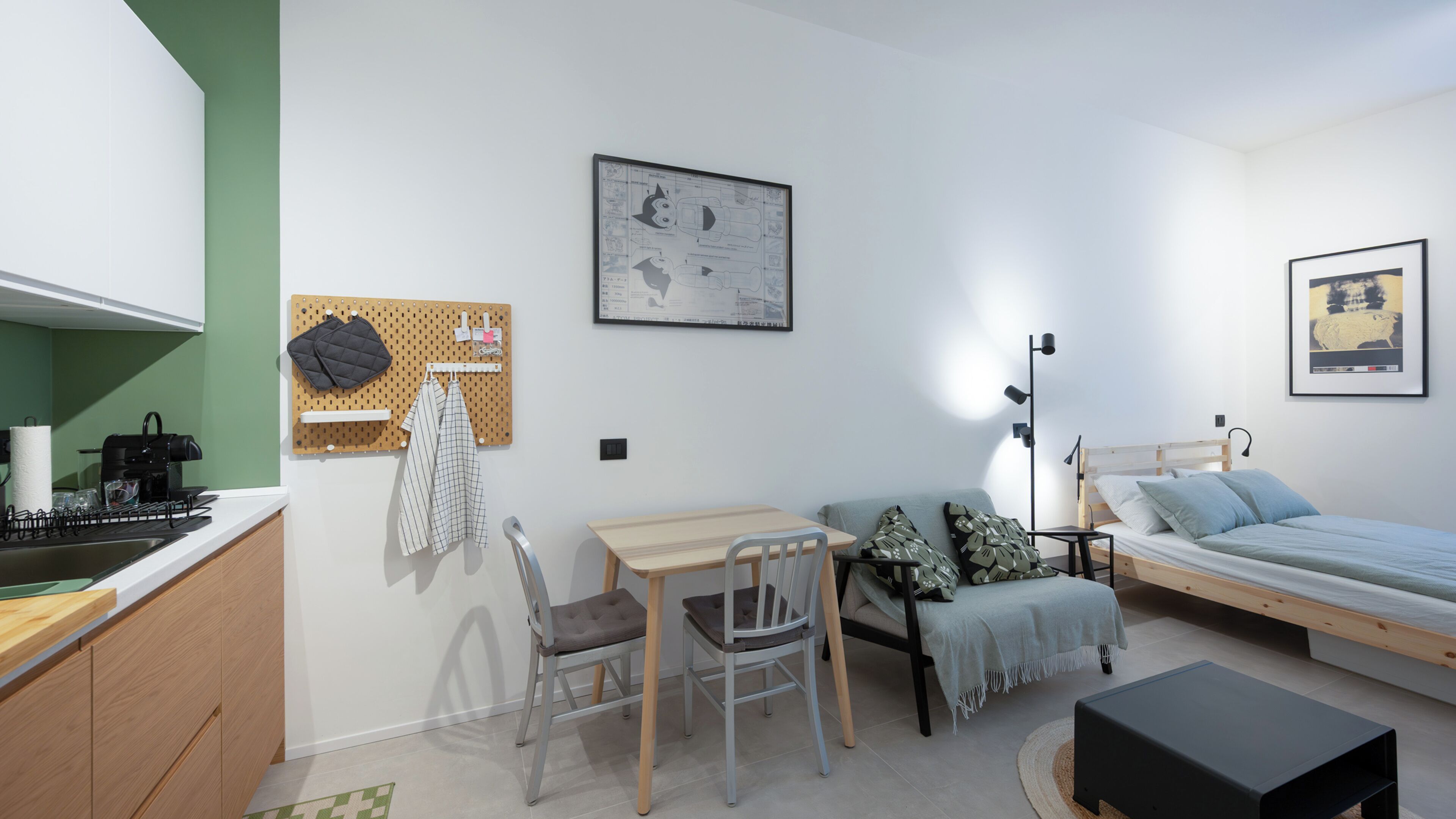 Une pièce de taille modeste comprenant un coin cuisine, un lit, un bureau et une chaise.