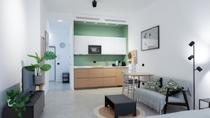 A modern living room with a sofa, a coffee table, and a TV stand with a plant. - Italianway Comfort - Rosmini 7 (Milan)