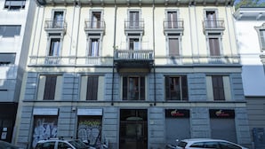 A multi-story building with balconies, a ground-level entrance, and signage for 'Li Feng BIGHIOTTERIA' and 'Mr. Ramen'. - Italianway Comfort - Rosmini 7 (Milan)