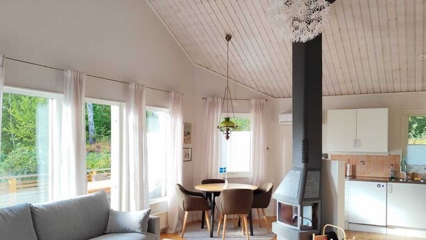 A modern living room with a sofa, coffee table, and dining area. - Stylish Lakehouse retreat with views over Djulö (Katrineholm)