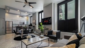 A modern living room with a sofa, coffee table, and a TV mounted on the wall. - Designer Boutique 2-Bedroom Apartment in the Heart of Old San Juan (San Juan)