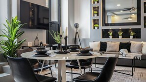A modern dining area with a round table, black chairs, and a sofa. - Designer Boutique 2-Bedroom Apartment in the Heart of Old San Juan (San Juan)