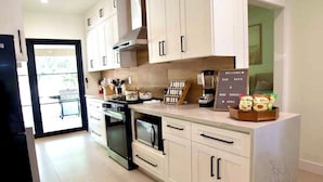 A modern kitchen with white cabinets, a built-in oven, and a coffee station. - The Ultimate OC Stay – NEW Stylish 6BR Home Perfect for Families & Groups! (Santa Ana)