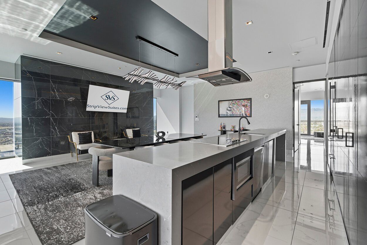 A modern kitchen with a marble backsplash, stainless steel appliances, and a large island.