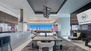 Una cocina moderna con una isla grande, una zona de comedor con billar y vistas al desierto.
