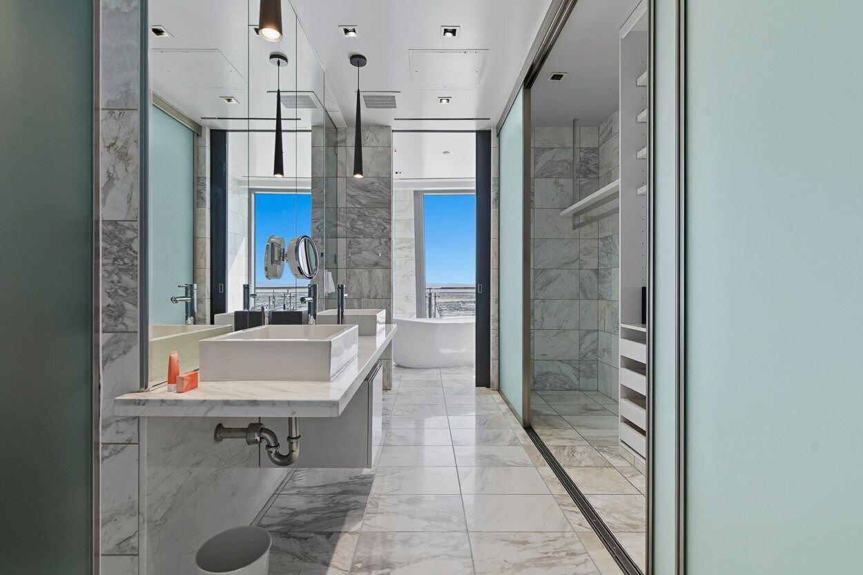 A modern bathroom with a large sink, a bathtub, and a glass shower enclosure.