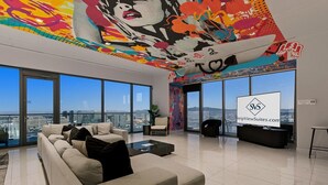 Un salón amplio con un sofá grande, una mesa de centro y una pantalla de televisión que muestra 'SVS StripViewSuites.com'.