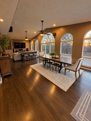 A spacious living area with a dining table, seating, and a television.