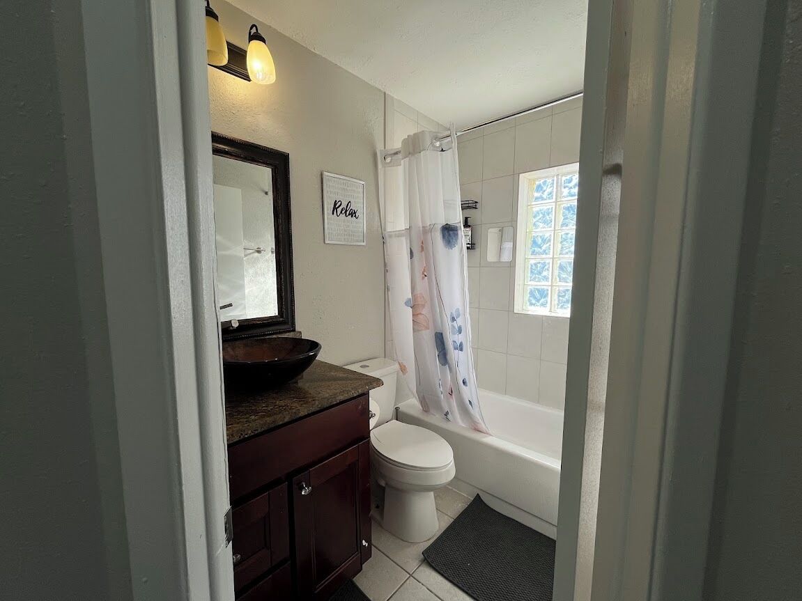 A bathroom with a toilet, sink, and bathtub.