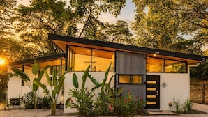 Una casa moderna con amplios ventanales, techo plano y diseño minimalista.