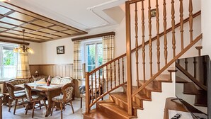 Ein Essbereich mit Holzmöbeln und einer Treppe mit Holzwertlauf.