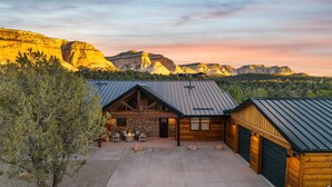 A log cabin with a stone foundation, a metal roof, and a concrete driveway. - The Vue: Perfect Base for Zion & Bryce Adventures (Orderville)