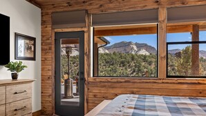 A bedroom with a large window offering a view of a mountainous landscape. - The Vue: Perfect Base for Zion & Bryce Adventures (Orderville)