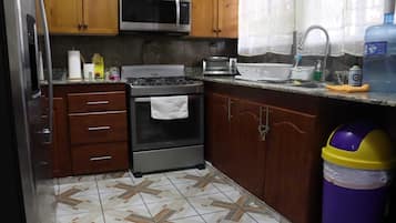 Quarto triplo básico, sacada, vista para o jardim | Cozinha privada