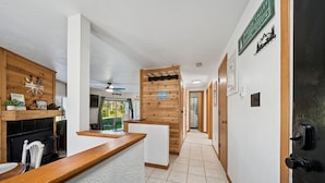 A hotel reception area with a wooden reception desk, a sign reading "Hidden Valley," and a sign indicating "Please remove your coat." - Charming 2-bedroom condo short walk to main lift (Somerset)