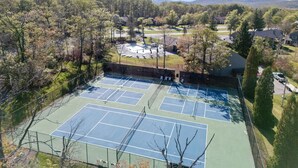 A tennis court surrounded by trees and houses. - Charming 2-bedroom condo short walk to main lift (Somerset)