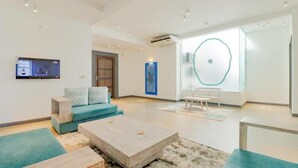 A modern living room with a sofa, coffee table, and a TV mounted on the wall. - Wonmi Residency (Galle)