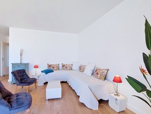 A modern living room with a sofa, a chair, a small table, and a lamp.