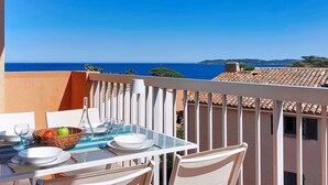 A balcony with a table set for dining, overlooking a coastal view. - La Marjolaine by Interhome (Sainte Maxime)