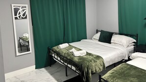 A bedroom with a bed, a nightstand, a mirror, and green curtains. - Charming 2-bedroom apartment in delightful Decatur with AC (Decatur)