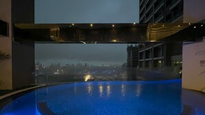 An indoor swimming pool with a cityscape view.
