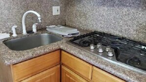 A kitchen with granite countertops, a stainless steel sink, a gas stove, and wooden cabinets. - Enjoyable an one bedroom unit in the heart of North Berkeley Hills  (Berkeley)
