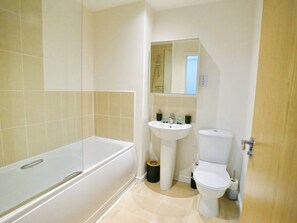 Un baño con bañera, lavamanos e inodoro.