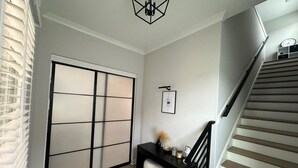 A modern interior with a sliding door, a black console table, and a staircase. - Luxury and Executive 4-bedroom house, Close to Blue Oval City (Arlington)