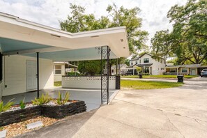 A residential property with a covered porch, a garage, and a landscaped front yard.