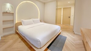 Un dormitorio moderno con una cama grande, una mesita de noche, un espejo y un armario.