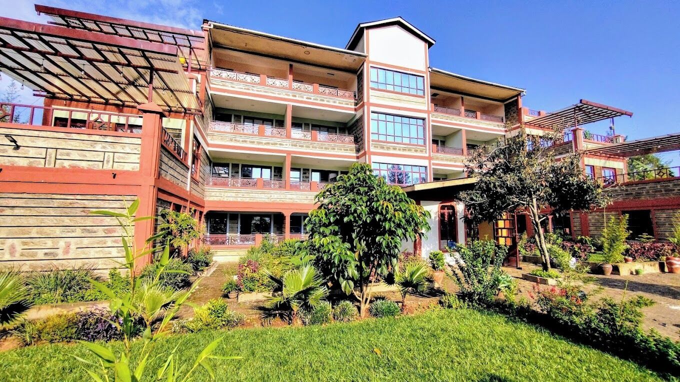 Um edifício de vários andares com varandas e um jardim.