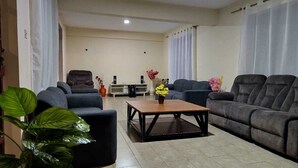 A living room with two sofas, a coffee table, and a TV stand. - Kusi hotel Kakamega (Kakamega)