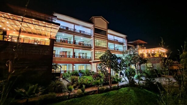 A multi-story hotel with balconies, a well-maintained garden, and a night-time view. - Kusi hotel Kakamega (Kakamega)
