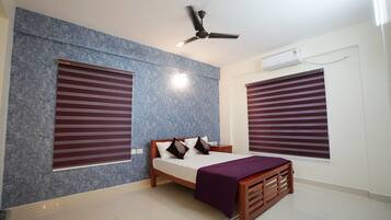 A bedroom with a bed, a ceiling fan, and an air conditioning unit.