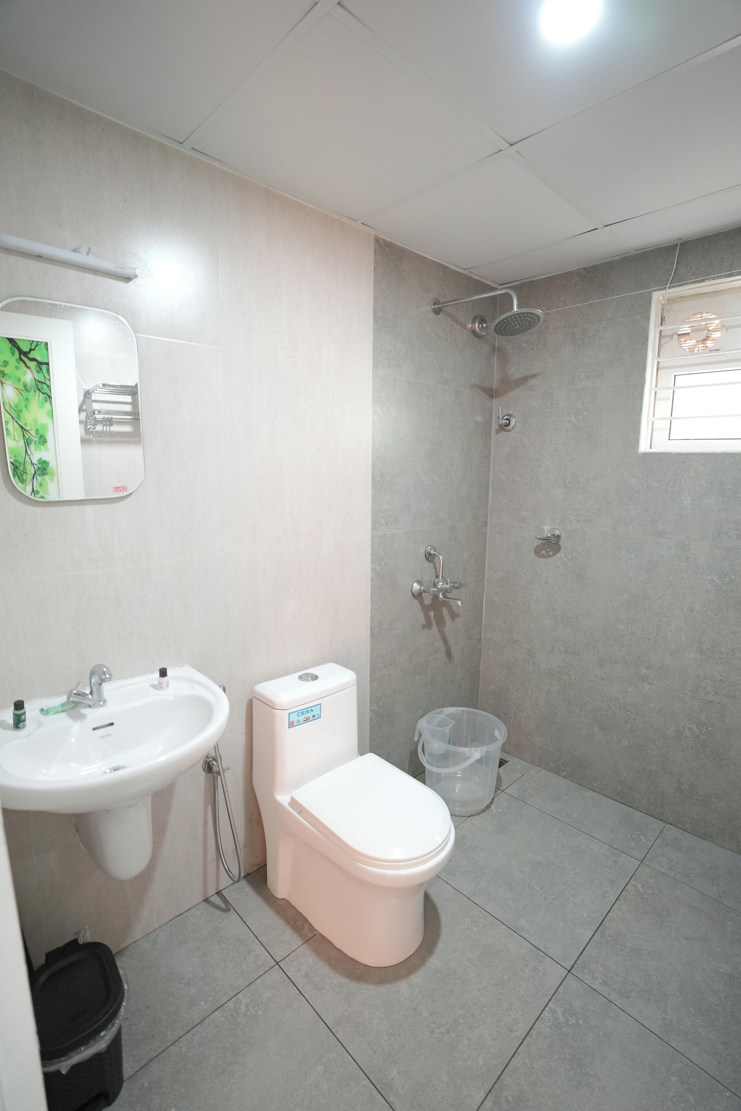 Une salle de bain équipée d’un lavabo, de toilettes, d’une douche et d’un miroir.