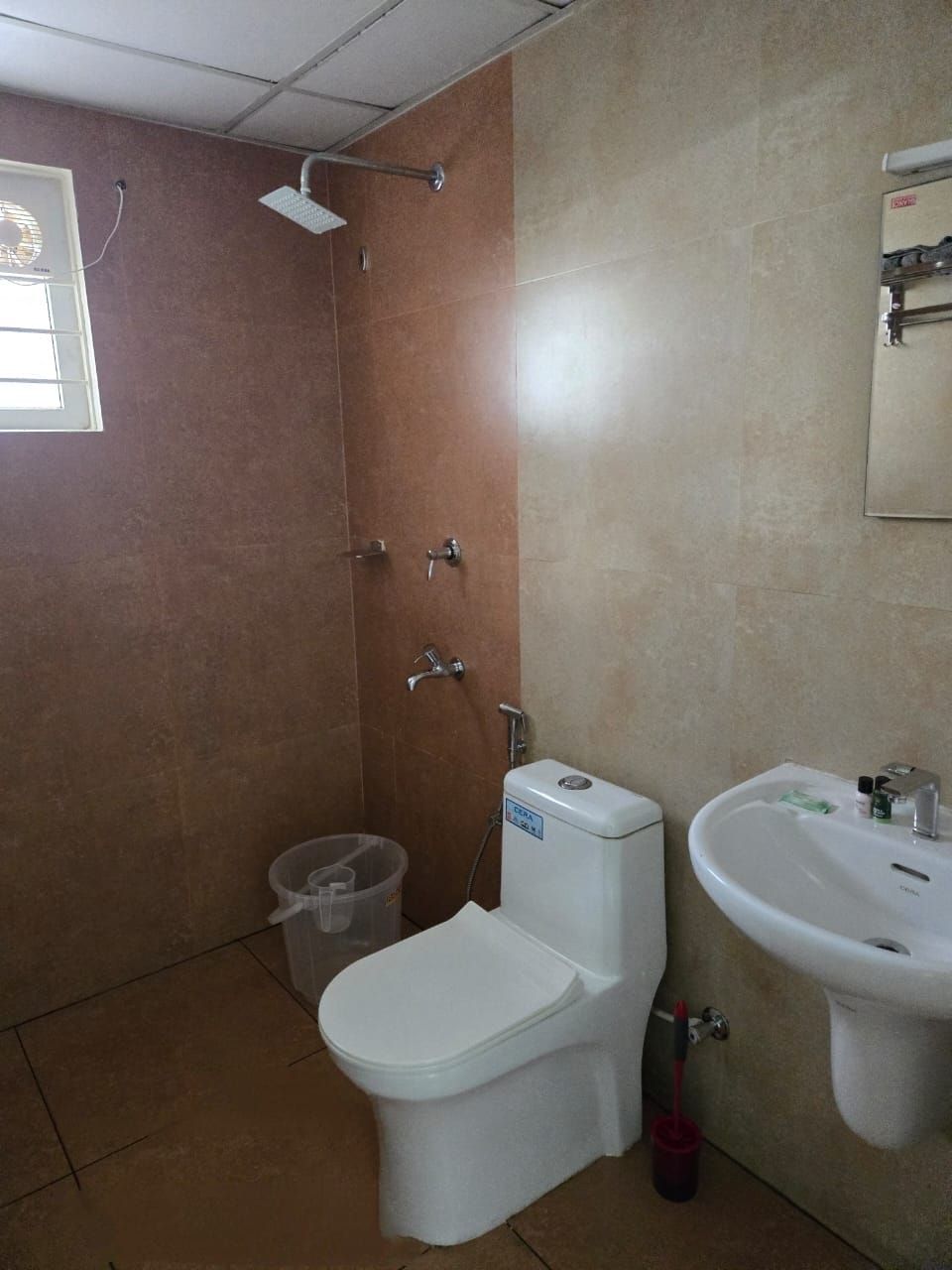 A bathroom with a toilet, bidet, sink, and shower.