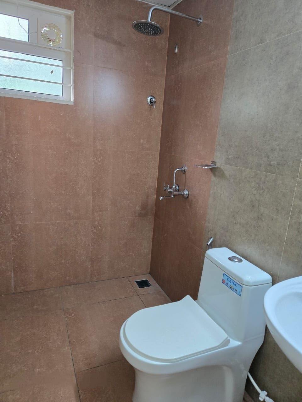 A bathroom with a shower, toilet, and sink.