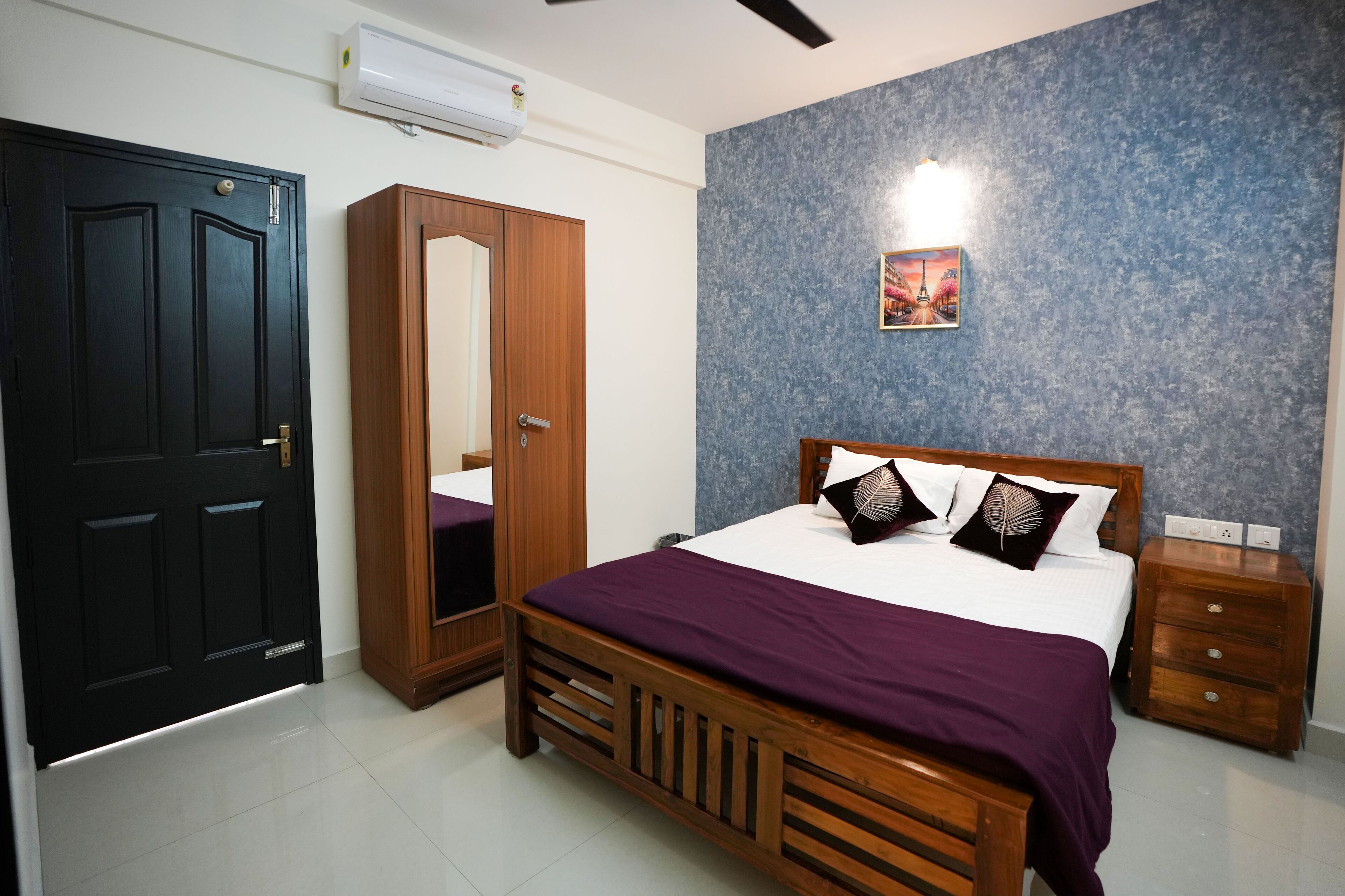 A bedroom with a wooden bed, a wardrobe, a nightstand, and a wall-mounted air conditioner.
