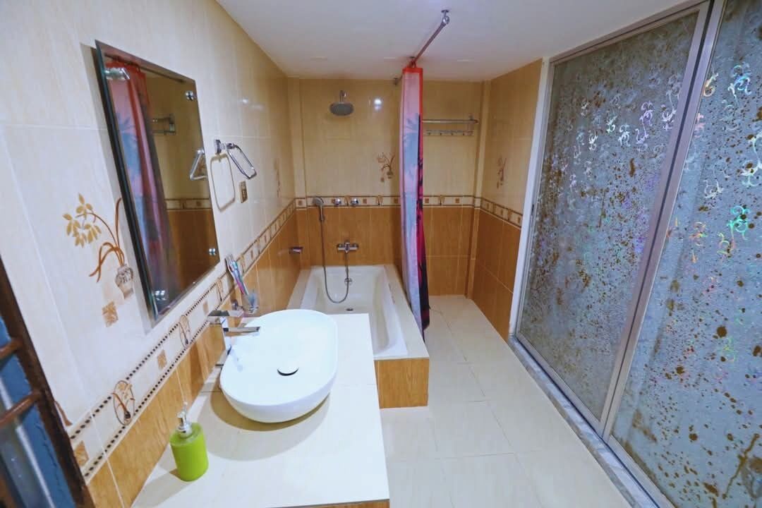 Une salle de bain avec un lavabo blanc, une baignoire et une douche.