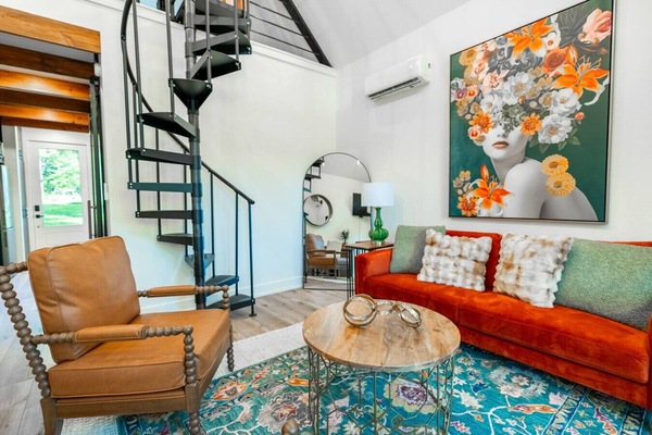 Open living area featuring a spiral staircase, curated décor, and comfortable seating.