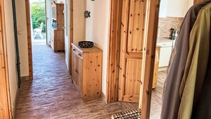 Un interno in legno con un corridoio che conduce a una zona cucina.