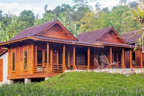 Eine Holzhütte mit Veranda und zwei Stühlen.
