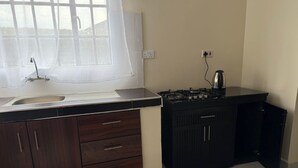 A kitchen with a sink, stove, and cabinets.