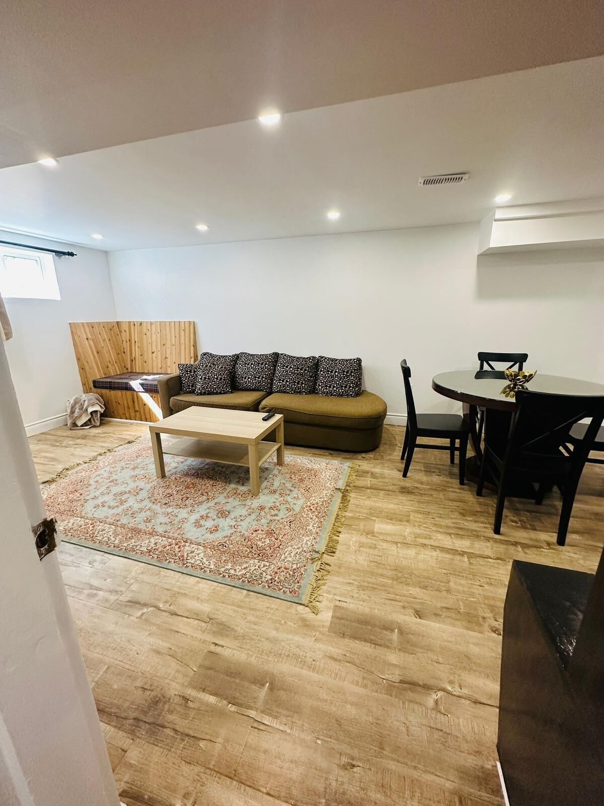 Een moderne woonkamer met een bank, een salontafel en een eethoek met stoelen en een tafel.