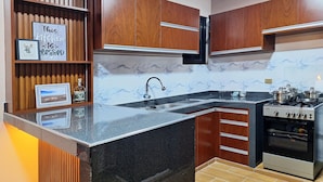 A kitchen with wooden cabinets, a marble backsplash, a built-in sink, and a stove. - Enjoyable 2-bedroom, 2-bathroom apartment with heating and Wi-Fi in Uyuni (Uyuni)