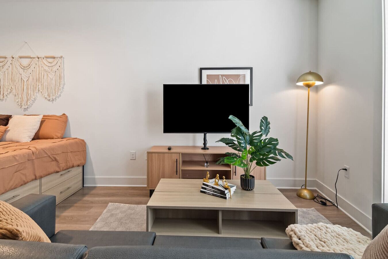 A modern living room with a sofa, coffee table, TV, and a floor lamp.