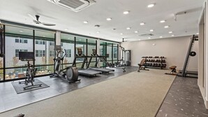 A modern gym with treadmills, elliptical machines, and free weights.